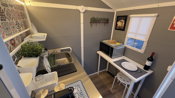 Fridge, microwave, coffee/tea maker, cookware/dishes/utensils