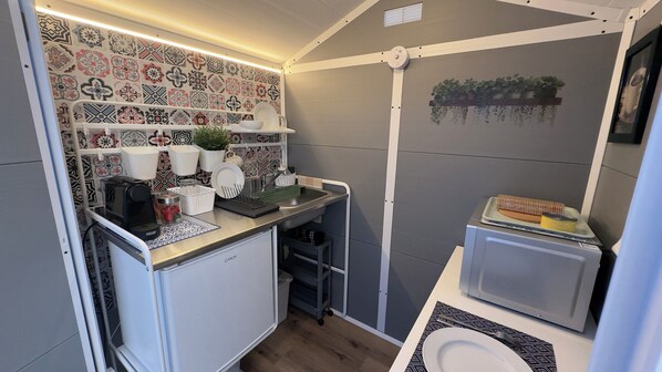 Fridge, microwave, coffee/tea maker, cookware/dishes/utensils