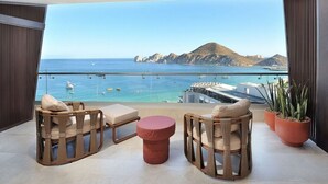 Ein Balkon mit Korbmöbeln, einem runden Tisch und Blumentöpfen.