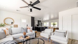 A modern living room with a sofa, armchairs, a coffee table, and a ceiling fan. - Family-Friendly Retreat with Heated Pool (Scottsdale)