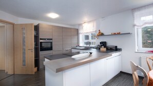 Una cocina moderna con una isla central, electrodomésticos integrados y una ventana con vistas.
