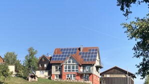 Una casa grande con techo inclinado y paneles solares.