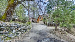 A rustic cabin with a stone wall and a wooden deck, surrounded by trees. - 'Lakeside Bear Lodge' Studio: 9 Mi to Bass Lake! (Wishon)