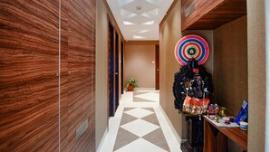A hallway with wooden walls, a geometric patterned floor, and a decorative wall hanging. - Fabhotel Royal Crystal (Bhubaneshwar)