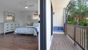A bedroom with a bed, dresser, and a balcony with a view of trees. - Unique A-Frame Heated pool & Firepit  (Cocoa)