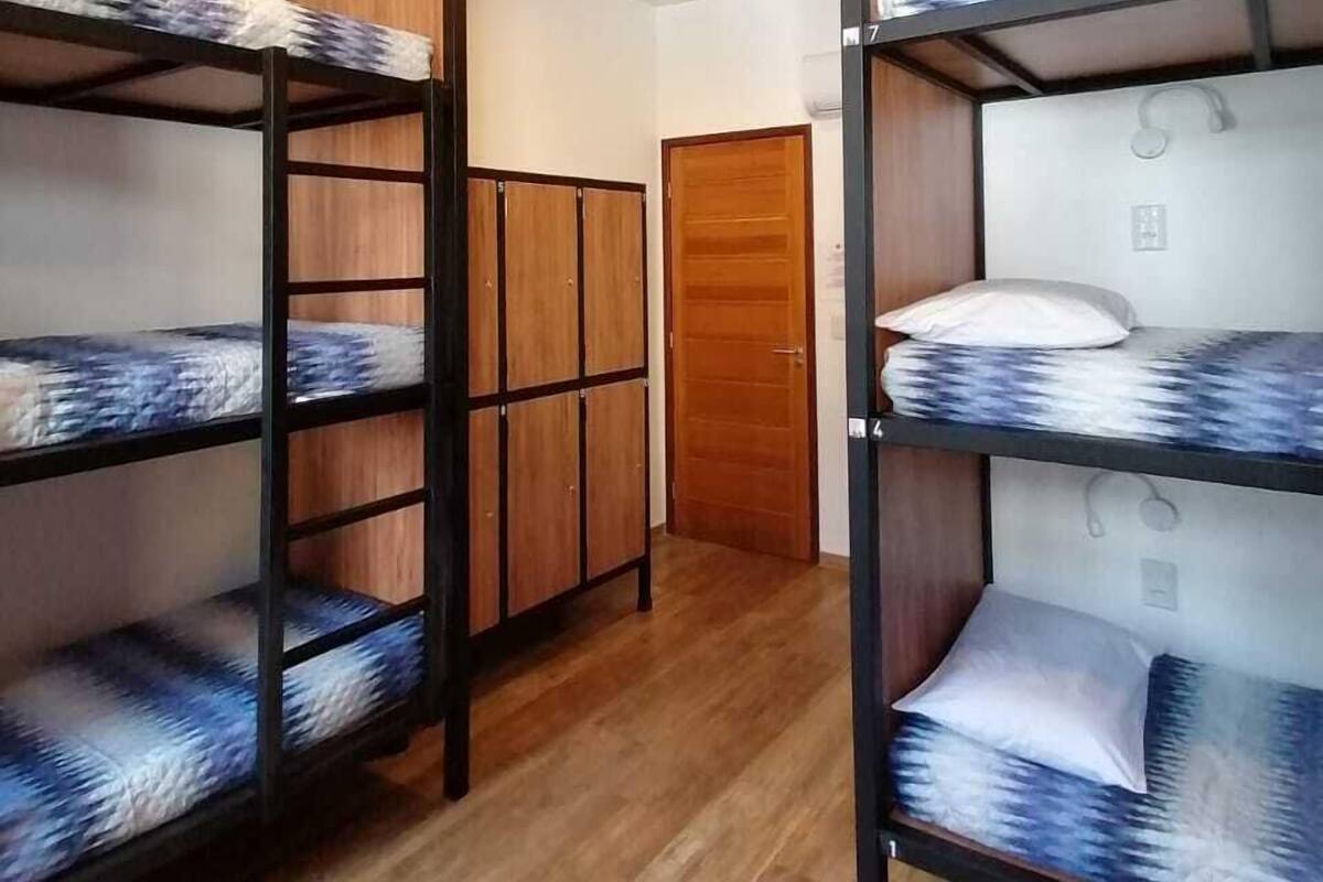 Una habitación con literas, un armario de madera y una puerta.