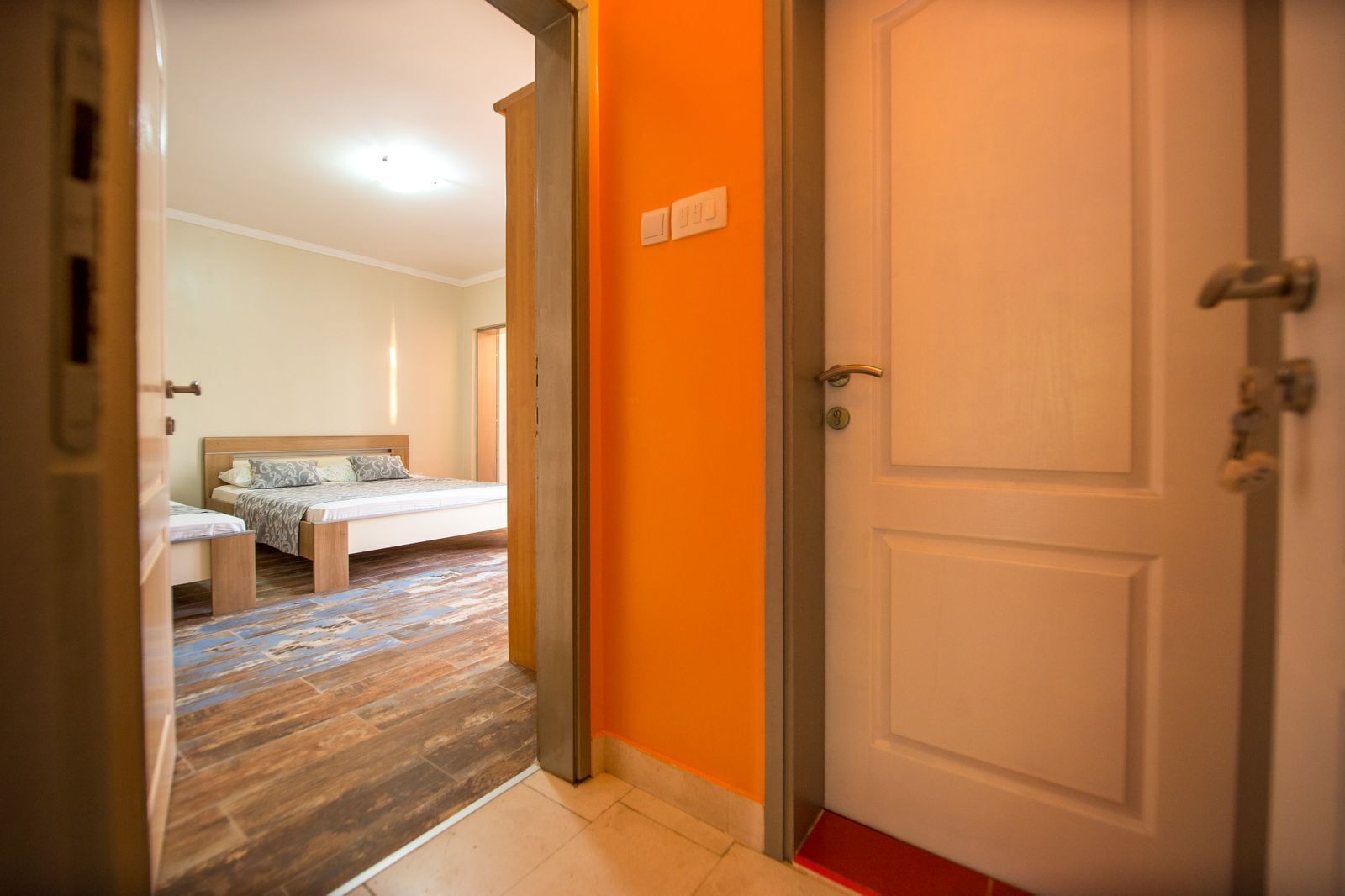 Een hotelkamer met een bed, een bankje en een tapijtvloer.