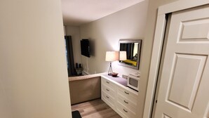 A narrow hallway with a wooden floor, a white door, a small table with a lamp, and a mirror on the wall. - ESCAPE TO THE PERFECT WHITE MOUNTAIN LOCATION - Cozy Condo @ Lincoln Station (Lincoln)