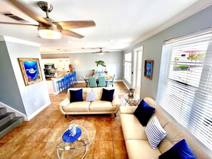 Relax in this inviting living space with a beige sofa, glass coffee table, and blue woven basket.
