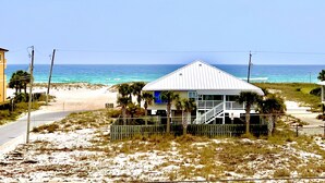 A beachfront property with a white house, a sandy beach, and the ocean in the background. - Luxury Gulf-View Beach Retreat Pool, Deck, Steps to Sand, Pet-Friendly, Sleeps 9 (Gulf Breeze)