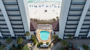 En vy över ett hotell från ovan, med en pool, en strand och palmer.