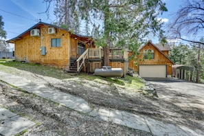 A wooden cabin with a garage, a covered deck, and a staircase leading to the upper level. - 9 Mi to Bass Lake: Cabin w/ Fire Pit in Wishon! (Wishon)