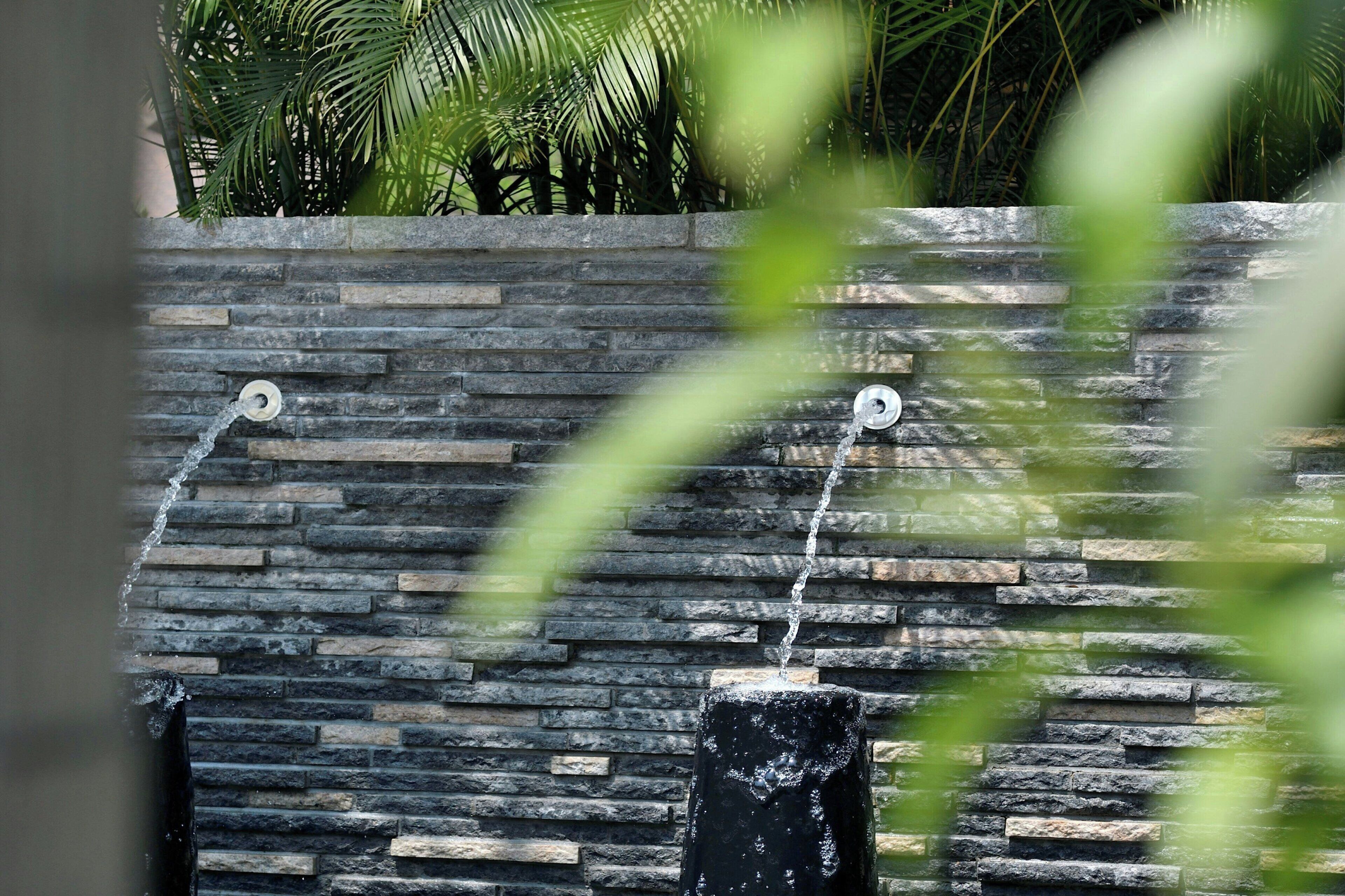 A stone wall with a water feature.