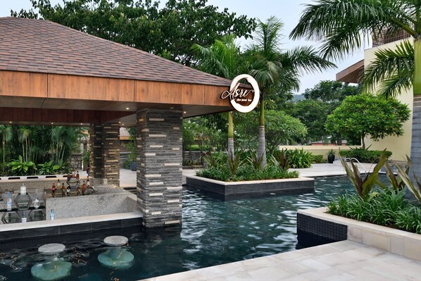 Una piscina al aire libre, sombrillas, sillones reclinables de piscina