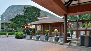 A covered outdoor area with a stone pathway, potted plants, and a waterfall feature.