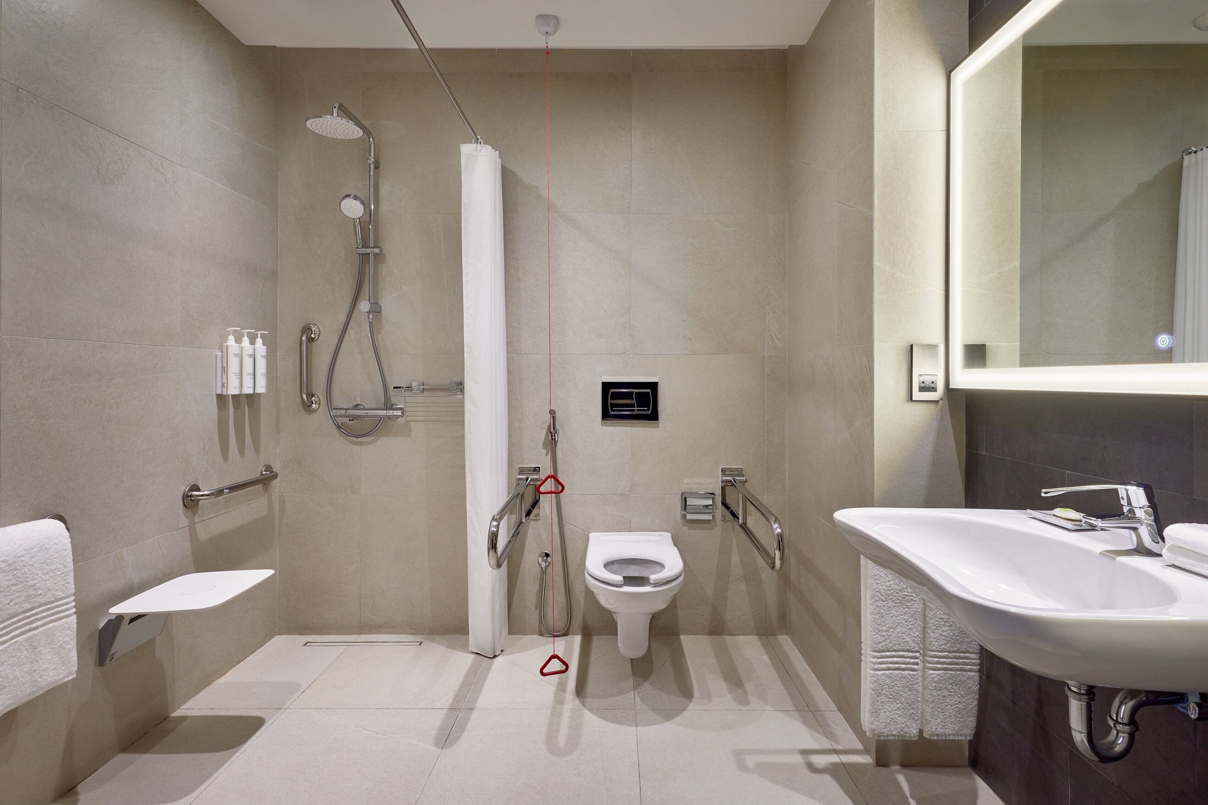 A modern bathroom with a shower, toilet, and sink.
