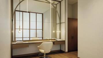 A modern bathroom with a large mirror, wooden vanity, and a white chair.