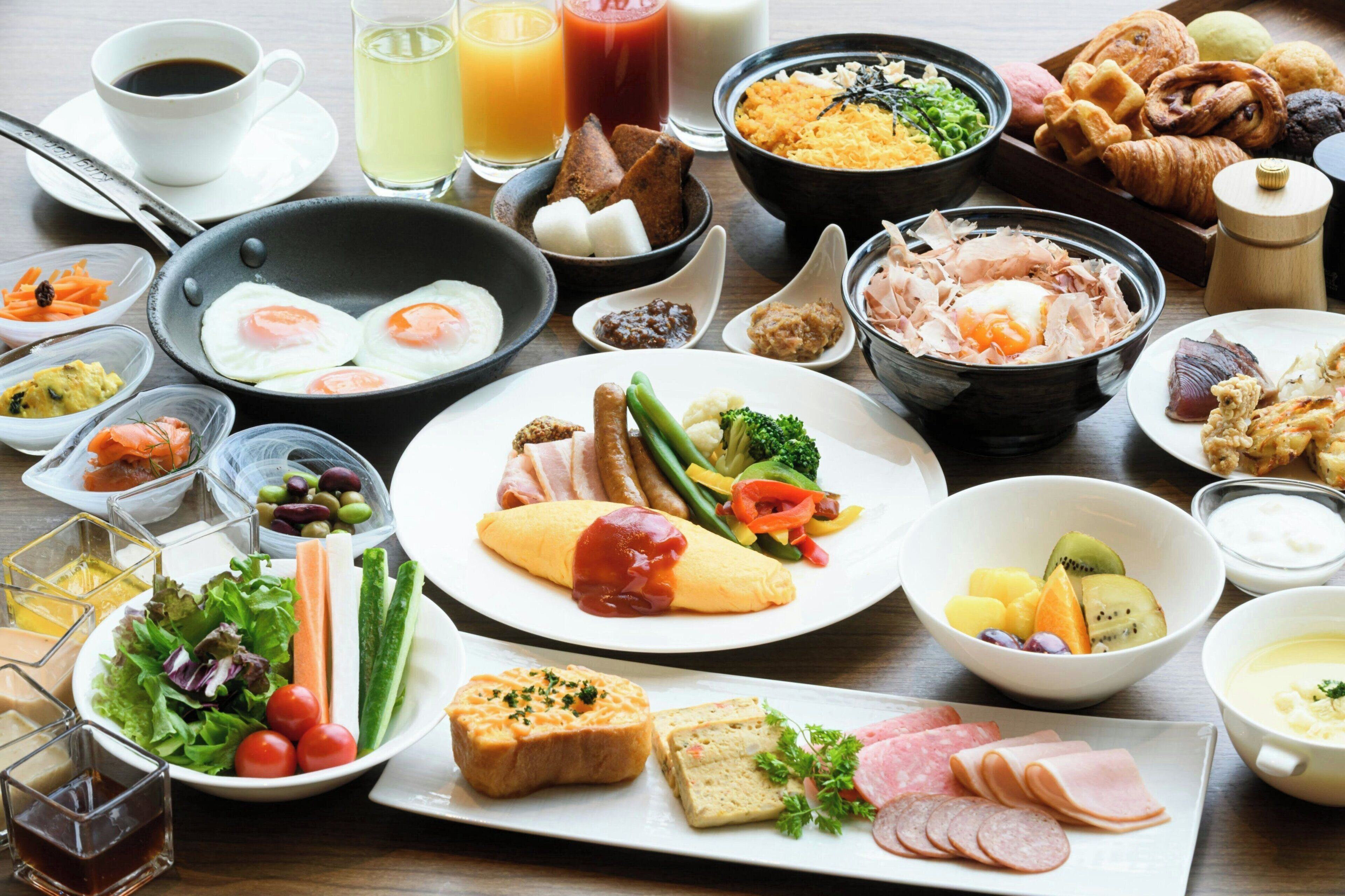 A variety of breakfast foods including eggs, meats, and vegetables on a table.