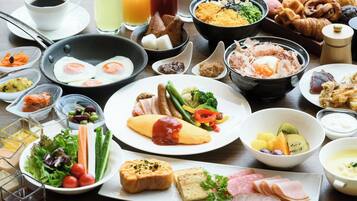A variety of breakfast foods including eggs, meats, and vegetables on a table.
