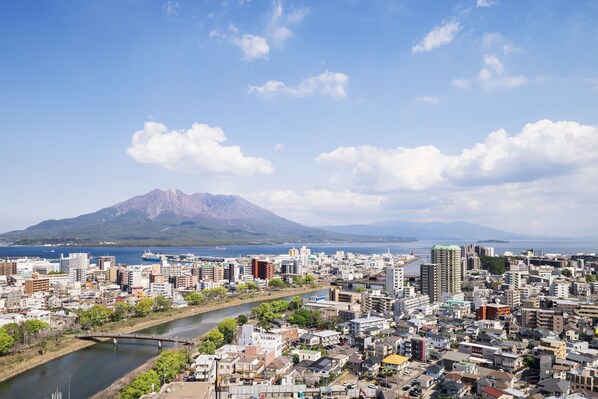 A cityscape with a river, buildings, and a mountain in the background.