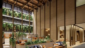 Un vestíbulo moderno con mostrador de recepción de madera, zona de estar y una escalera.