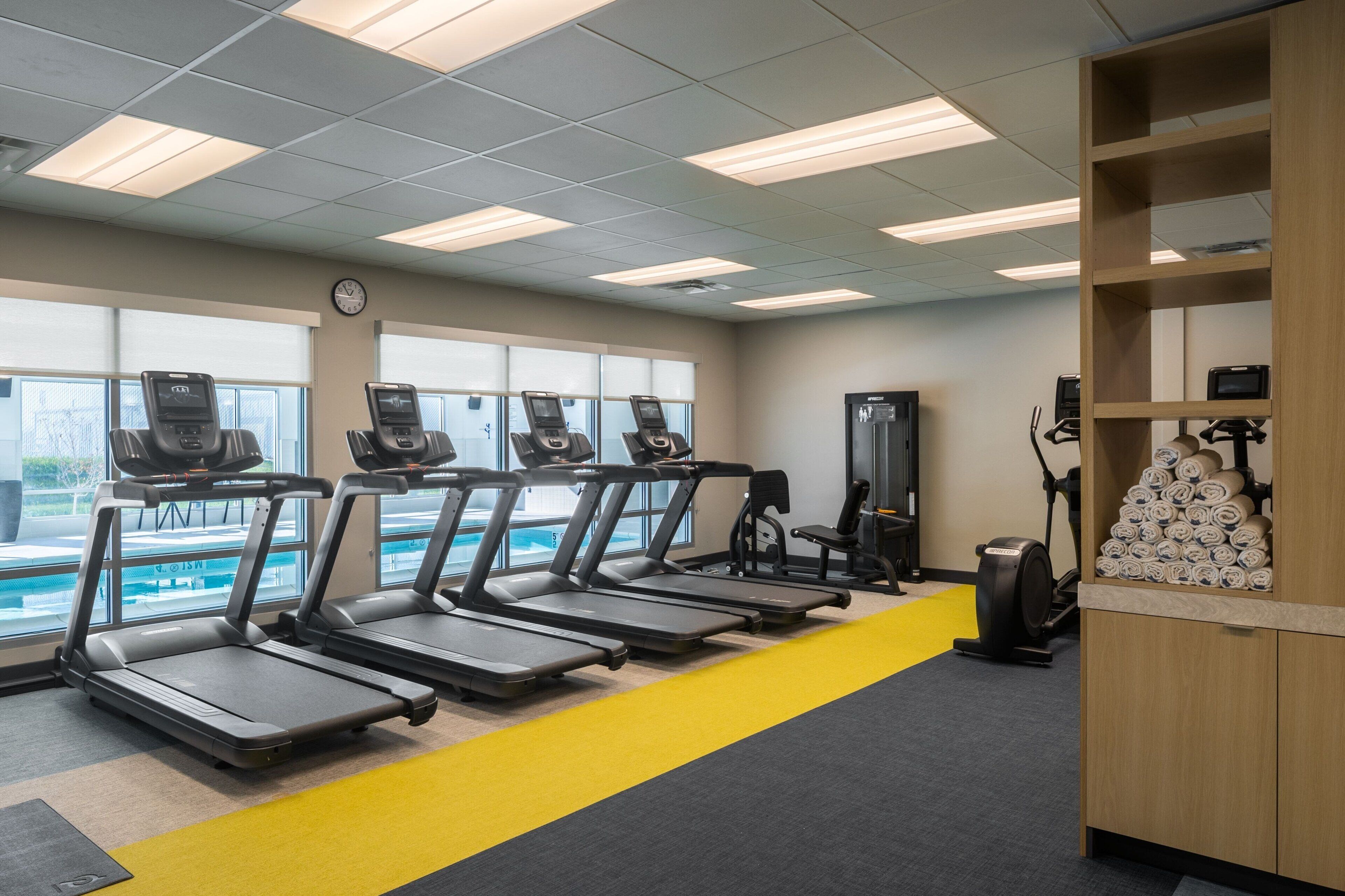 A gym with treadmills, exercise bikes, and a weight machine.