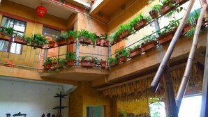 Een gebouw met meerdere verdiepingen en balkons, versierd met potplanten.