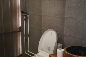 A bathroom with a toilet, a shower, and a large basin. - Yuanyang Green Hostel & Sunny Guesthouse (Yuanyang)