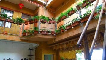 Un atrio de varios niveles con balcones decorados con plantas en macetas.