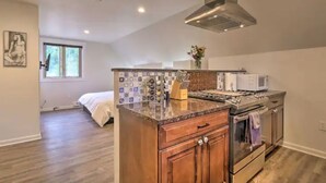 A modern kitchen with a central island, built-in oven, and stainless steel appliances.