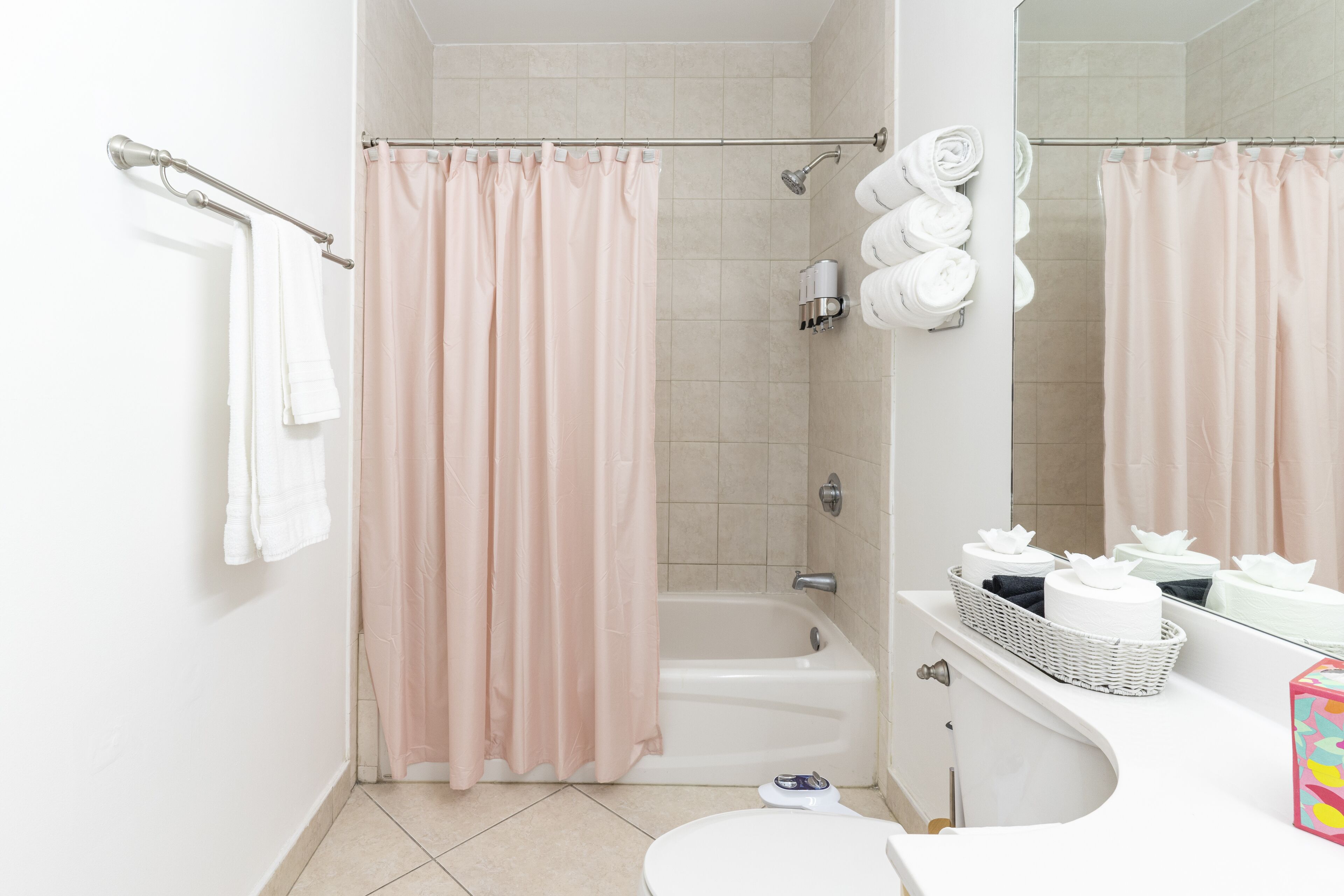 A bathroom with a bathtub, a toilet, and a shower curtain.