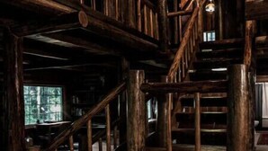A wooden staircase with a rustic design, leading to an upper level.