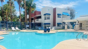 A swimming pool with lounge chairs, a building with a number 11, and palm trees. - Cozy 2 bedroom apartment in Las Vegas (Las Vegas)