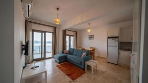 Una sala de estar con un sofá, una mesa de comedor y una zona de cocina.