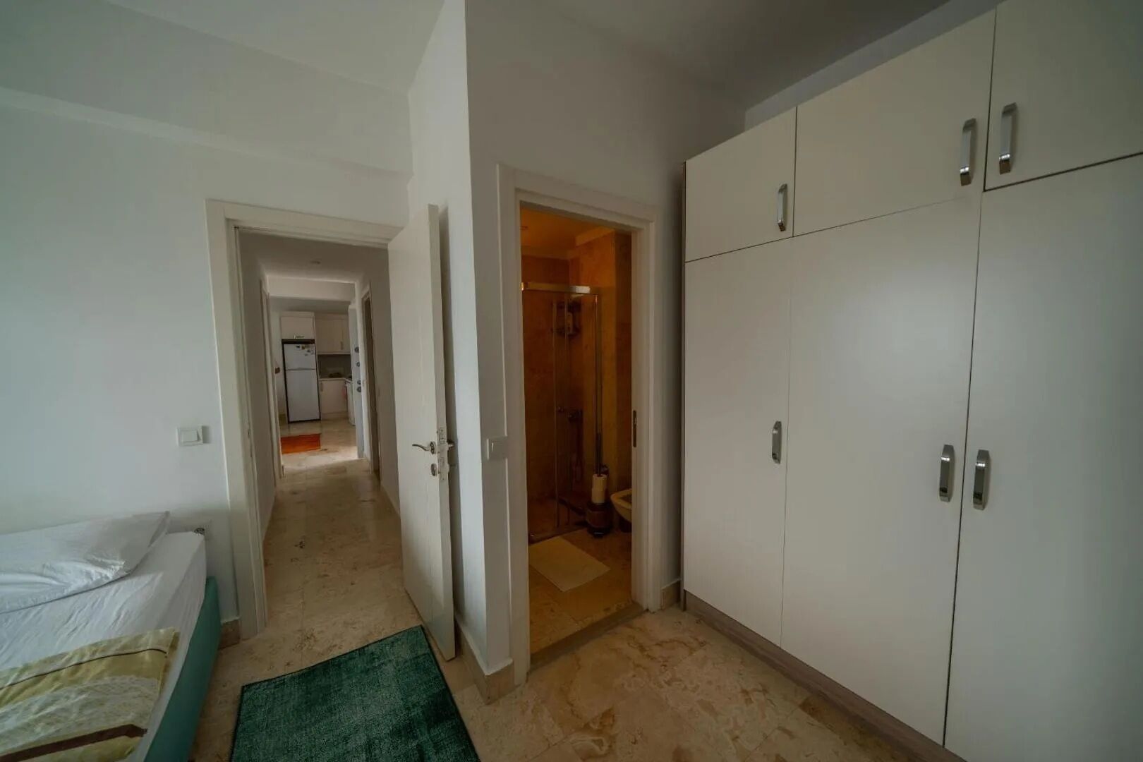 Se ve una habitación con una cama, un armario y un baño abierto.