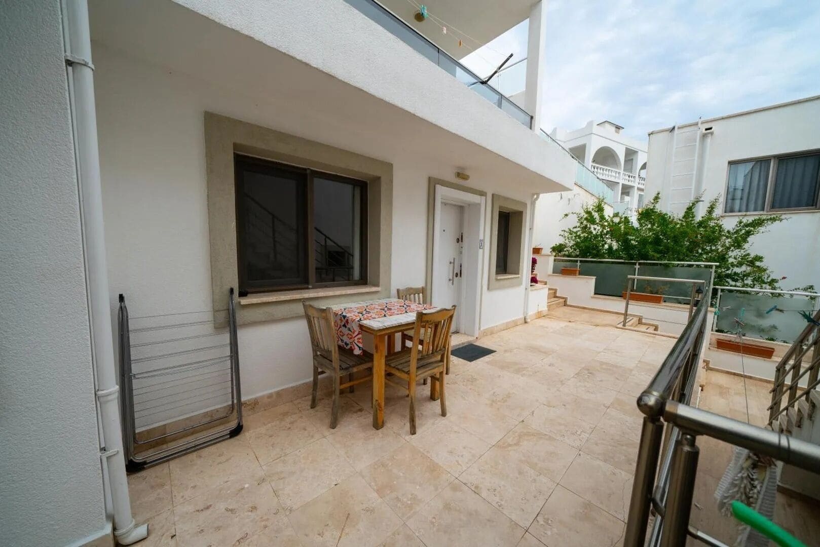 A patio area with a table and chairs, a window, and a door.