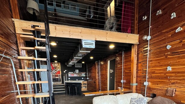 A modern interior with a staircase, a sofa, and a dining area. - Amazing repurposed grain elevator! (Sabin)