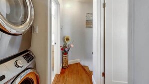 A laundry room with a washing machine, dryer, and a vase with flowers. - JadeHome -- Townhome style (Alameda)
