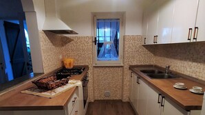 Une cuisine compacte dotée d’un îlot central, d’une fenêtre offrant une belle vue et d’un évier.