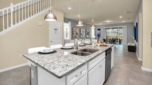 A modern kitchen with granite countertops, stainless steel appliances, and pendant lighting. - Magical Themed Villa in Windsor Isalnd (Davenport)