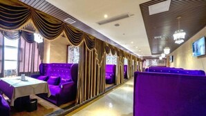 A restaurant with purple booths and a long counter. - Siyuan Hotel (Chishui)