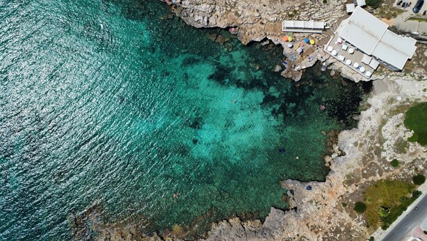 A coastal area with clear turquoise waters, rocky terrain, and a building with a flat roof near the shore. - Exclusive Private Villa with Pool & Jacuzzi Surrounded by Citrus Trees – Salento (Taviano)
