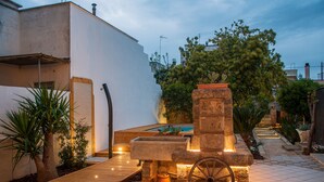 A courtyard with a stone fountain, a wooden pathway, and a pool. - Exclusive Private Villa with Pool & Jacuzzi Surrounded by Citrus Trees – Salento (Taviano)