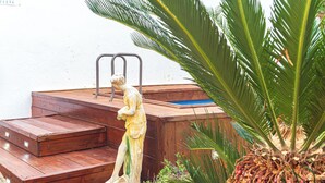 A wooden bench with steps, a statue, and a palm tree. - Exclusive Private Villa with Pool & Jacuzzi Surrounded by Citrus Trees – Salento (Taviano)