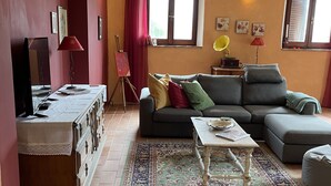 A living room with a sofa, a coffee table, a TV, and a rug.