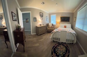 A bedroom with a bed, dresser, chair, and a small rug. - Centrally located. Charming brick home.  Quiet neighborhood.  (West Monroe)