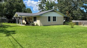 A single-story house with a sloped roof, a covered porch, and a well-maintained lawn.