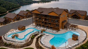 A resort with a large pool, multiple guest rooms, and a view of a lake. - Hot Tub, Lake & Mtn Views, King Beds, Bunk Room (Kimberling City)