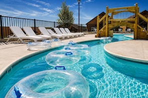 Una piscina con sillas de descanso y flotadores.