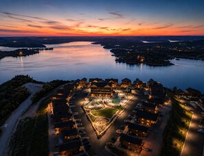 Un complejo turístico con un patio central, edificios interconectados y vistas al lago.